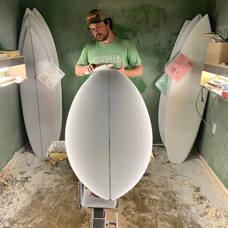 DJ Kane shaping a surfboard in shop