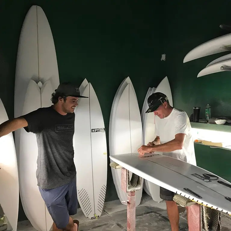 DJ Kane working with Jon Pyzel on a custom design surfboard